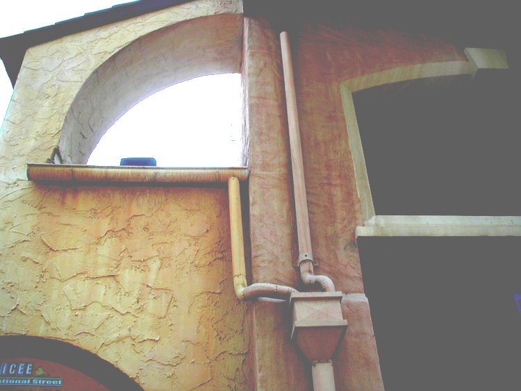 A system of gutters and downspouts protect the wall.