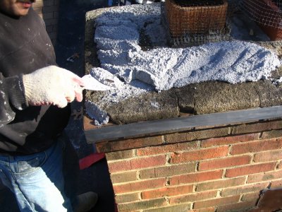 Putting mortar on chimney cap